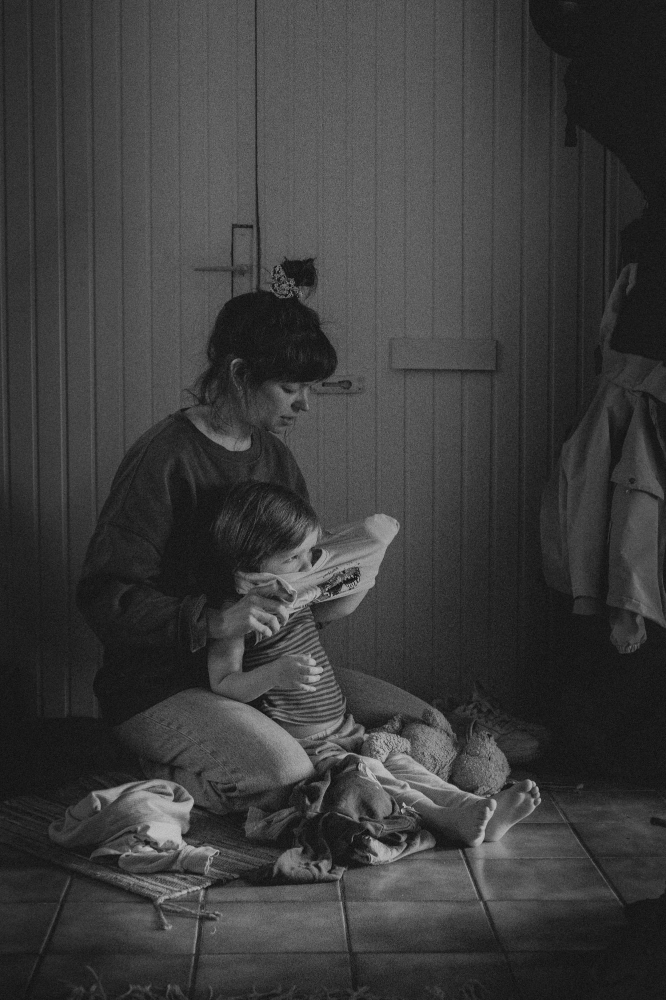 Mutter zieht Kind an - authentische Familienfotografie