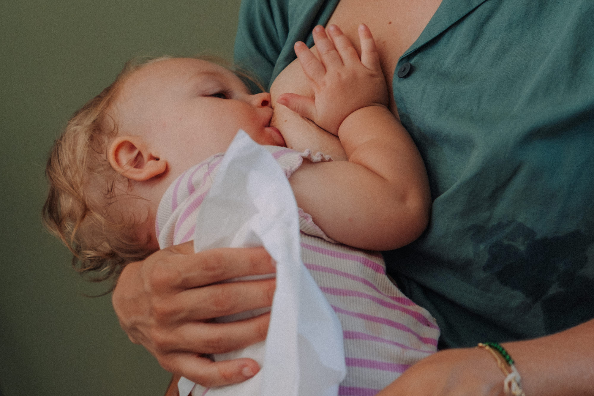 Stillende Mutter hält Baby liebevoll im Arm – natürliche Stillfotos