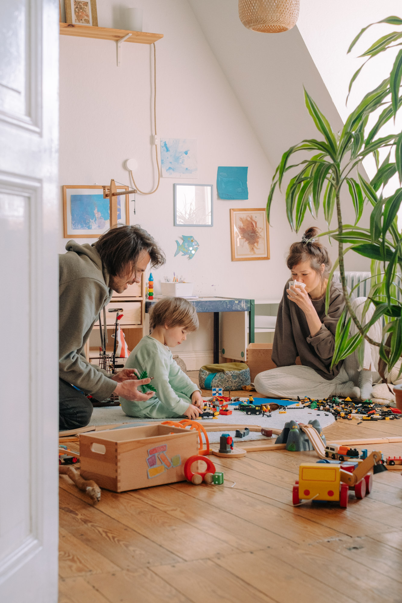 Eltern spielen mit Kindern im Wohnzimmer – dokumentarische Familienreportage