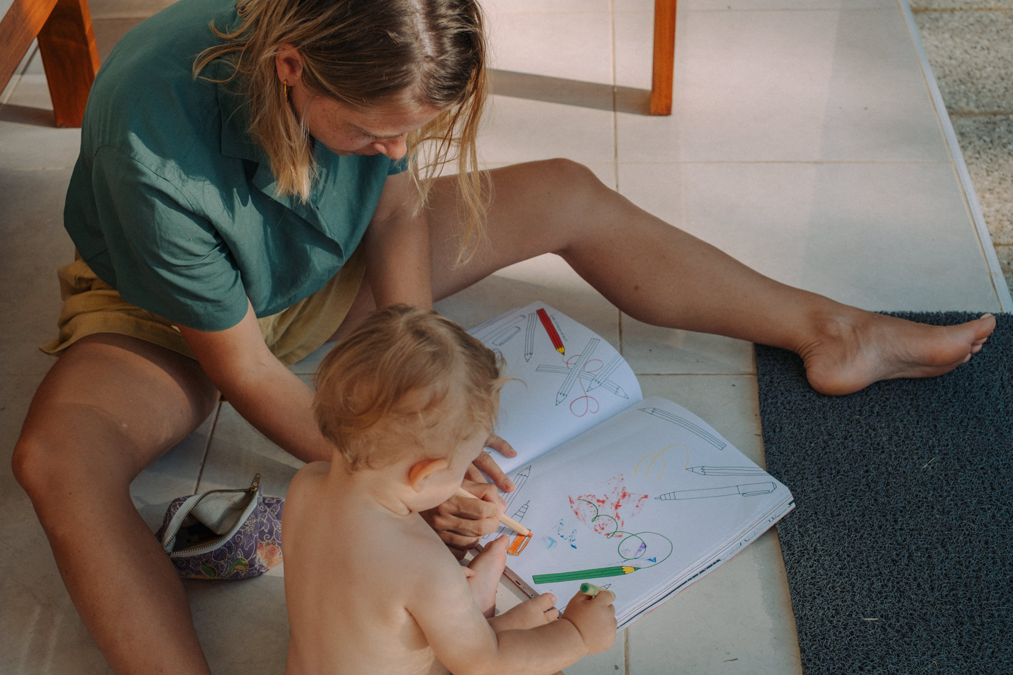 Mutter malt mit Kleinkind auf dem Boden – kreative Familienmomente zu Hause